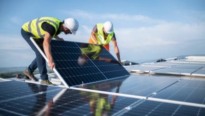 Team of two engineers installing solar panels on roof. Team of two engineers installing solar panels on roof.